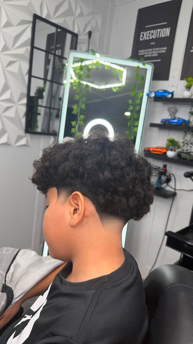 YM Blends haircut with a curly top and clean fade