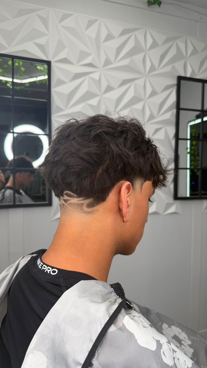 YM Blends haircut with a shaved design detail