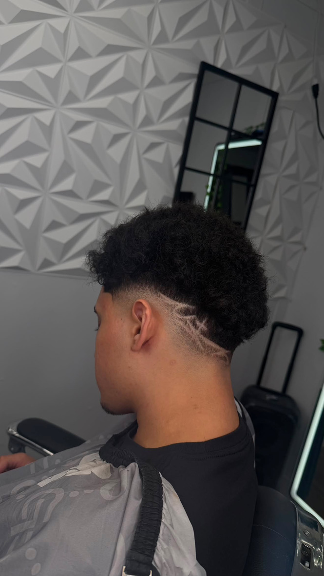 YM Blends haircut featuring a custom shaved design